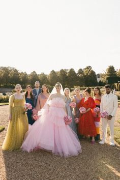 a group of people standing next to each other in front of a lush green field