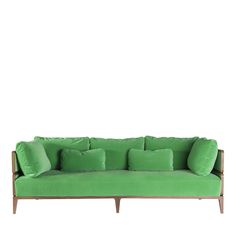 a green couch with four pillows on it