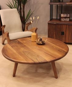 a wooden coffee table sitting on top of a hard wood floor next to a white chair