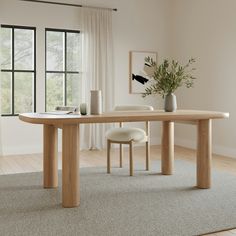 a dining table with two chairs and a vase on the top, in front of a window