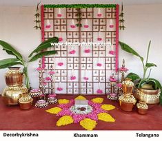 there are many pots and vases on the table in front of a wall with flowers