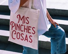 a person carrying a bag with the words miss pinches cosas on it while walking up some steps