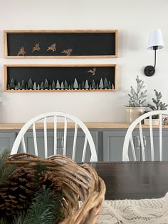 the dining room table is set with white chairs and pine cones on top of it