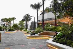 the walkway is lined with planters and benches that are lit up by led lights