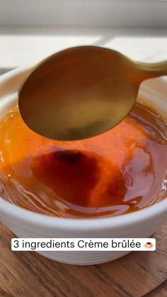 a spoon is pouring sauce into a white bowl on a wooden table with the words 3 ingredients creme brulee