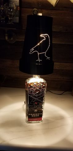 a lamp that is sitting on top of a table next to a light fixture with a bird drawn on it