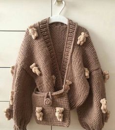 a teddy bear sweater hanging on a wall