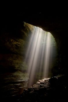 the light is shining through an opening in a cave