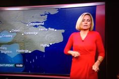 a woman is standing in front of a weather map