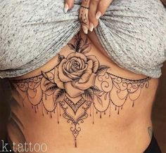 a woman's stomach with a rose tattoo on the side and an intricate design