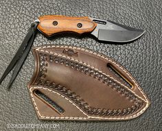 a knife and sheath on top of a leather case