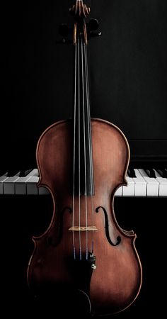 a violin sitting on top of a piano