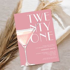 a pink card with the words two city one on it and a glass of wine