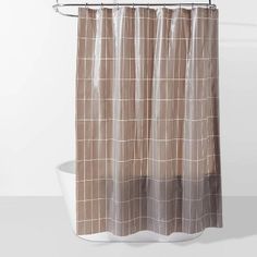 a shower curtain with a brown and white checkered pattern on the bottom, hanging from a metal rod