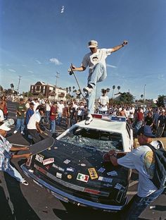 a man riding a skateboard on top of a car in front of a crowd