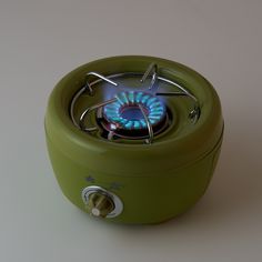 a small green stove on a white surface