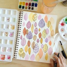 someone is painting leaves with watercolors on paper