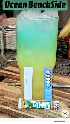 a green and blue drink sitting on top of a wooden table