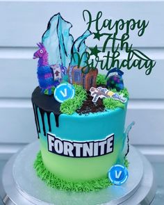 a birthday cake with fortnite decorations on it and the words happy birthday written in green frosting