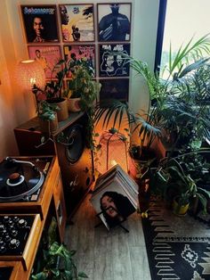 a room with plants and records on the floor