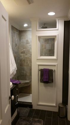 a bathroom with a sink, toilet and shower stall in the corner next to an open door