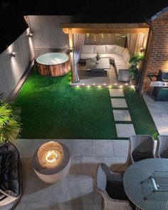 an outdoor living area is lit up at night with lights on the patio and lawn