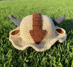 a crocheted hat with horns is laying in the grass