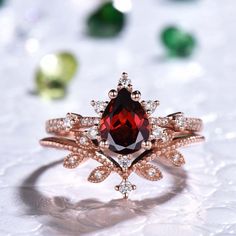 a ring with a large red stone surrounded by small white diamonds on top of it