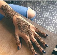 a woman's hand with henna tattoos on it