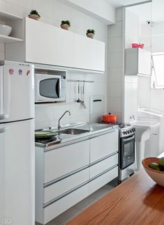a kitchen with white cabinets and appliances in the corner, including a bowl of fruit on the counter