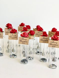 there are many wine bottles with red roses in them and tags on the top one