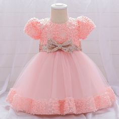 a pink dress with flowers and a bow on it