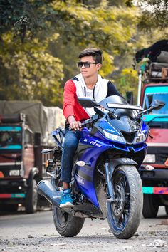 a man riding on the back of a blue motorcycle