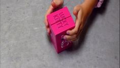 a person holding a pink object with the words happy birthday written on it in small letters