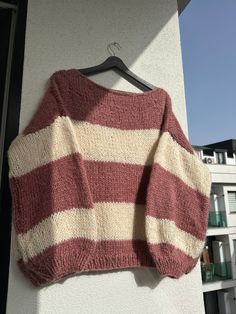 a red and white striped sweater hanging on a wall