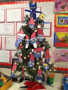 a decorated christmas tree in an office cubicle with lots of paper cutouts on it