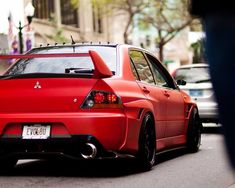 a red car is parked on the street