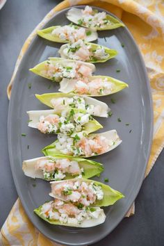 lobster and lettuce cups are arranged on a gray platter with yellow napkins