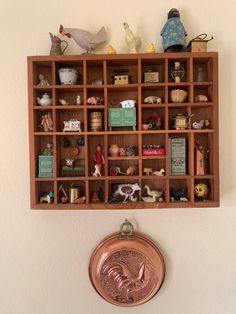 a wooden shelf filled with figurines on top of a wall