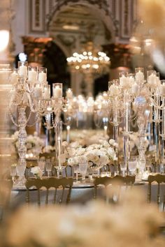 the tables are set up with white flowers and candles