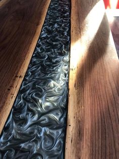 water flowing down the side of a wooden table in a restaurant or bar with sunlight shining on it