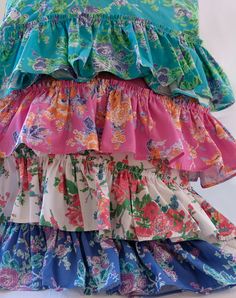 three tiered skirts are stacked on top of each other, one is blue and the other is pink