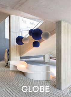 the interior of a building with blue and white balls hanging from it's ceiling