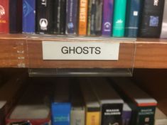 there is a shelf with many books in the library that are labeled ghost's