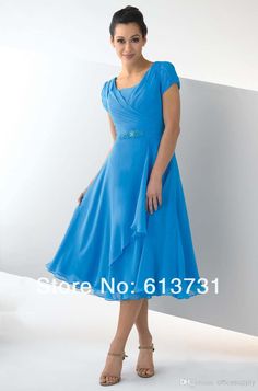 a woman in a blue dress posing for the camera with her hands on her hips