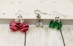 three pairs of earrings sitting on top of a wooden floor