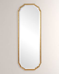 a gold framed mirror hanging on the wall