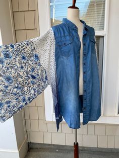 a blue jean jacket is hanging on a mannequin in front of a window