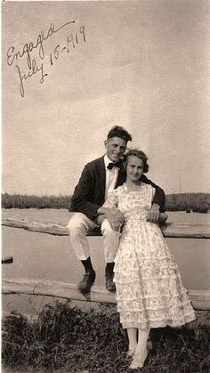 an old photo of a man and woman sitting on a bench