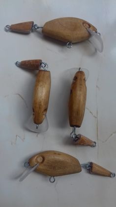 four wooden fishing lures are shown on a white surface